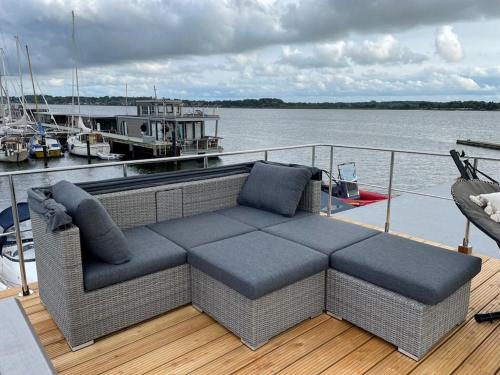 un canapé assis sur le pont d'un bateau dans l'établissement Hausboot Fjord Schleiliebe mit Biosauna und Dachterrasse in Schleswig, à Schleswig