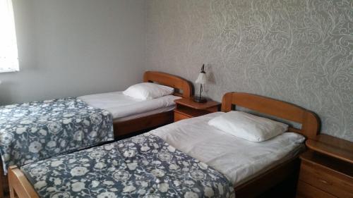 two twin beds in a room with a wall at Villa Lena in Gdańsk