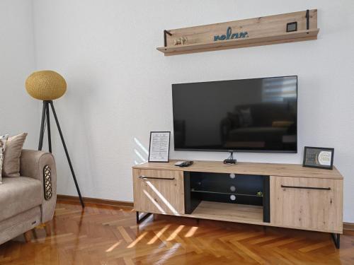 Apartman NiRa في فيشغراد: غرفة معيشة مع تلفزيون على مركز ترفيهي خشبي