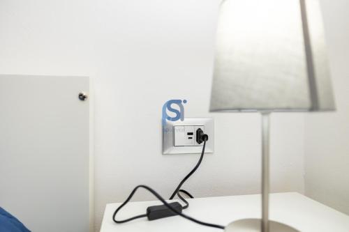 a lamp sitting on a table next to a lightswitch at Il Vittoria - Self Check in in Lascari