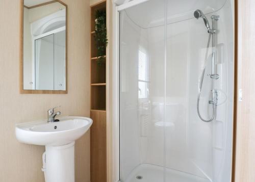 a bathroom with a white sink and a shower at Awesome Home In Clynderwen With in Clynderwen
