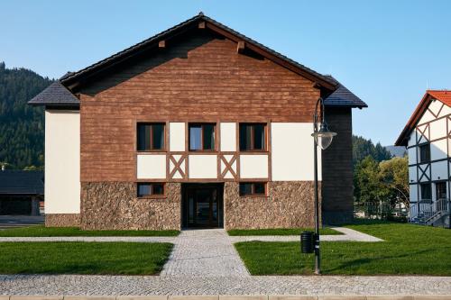 a brown and white building with a street light at Rezort Gothal Chalupy in Donovaly