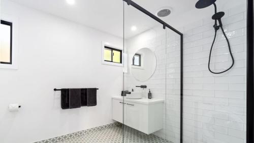 Un baño blanco con lavabo y ducha. en Glen Tara, en Johanna