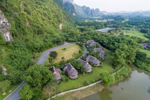 una vista aerea di un villaggio con un fiume e montagne di Serena Kim Boi Resort - Hoa Binh a Hòa Bình