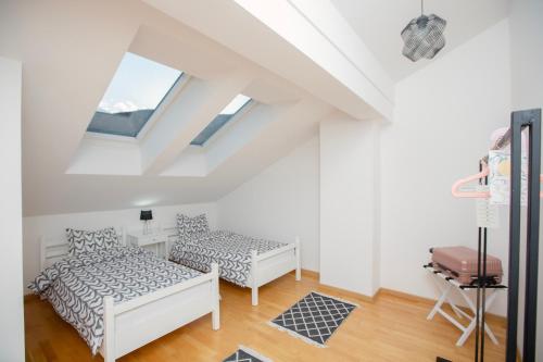 Cette chambre mansardée comprend 2 lits et une fenêtre. dans l'établissement Apartment Cejf Mostar, à Mostar
