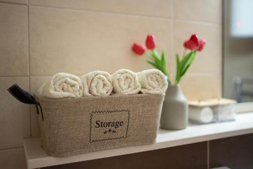 ein Korb mit Handtüchern auf einer Badezimmertheke mit Blumen in der Unterkunft Apartment Cejf Mostar in Mostar