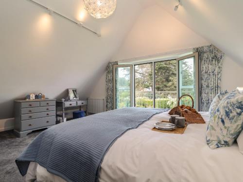 a bedroom with a large bed and a window at Little Chapter in Southwold