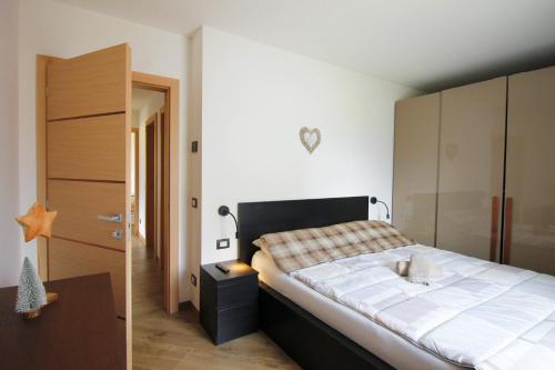 - une chambre avec un grand lit et une armoire en bois dans l'établissement CASA YARA - appartamento moderno, Dolomiti Affitti, à Cavalese