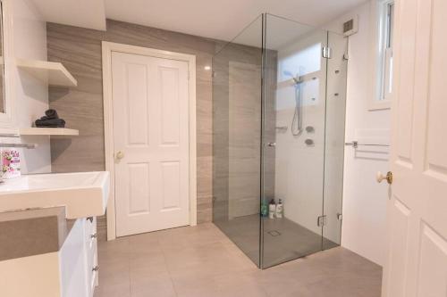 a bathroom with a shower with a glass door at The Grange country retreat, with a birds eye view! in Mittagong
