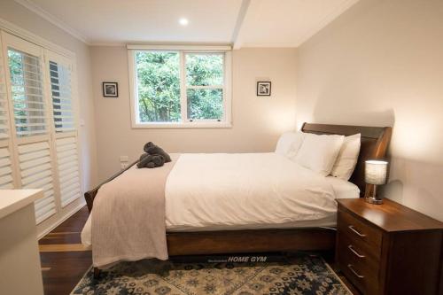 a bedroom with a bed with a teddy bear on it at The Grange country retreat, with a birds eye view! in Mittagong