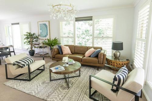 a living room with a couch and a table at The Grange country retreat, with a birds eye view! in Mittagong
