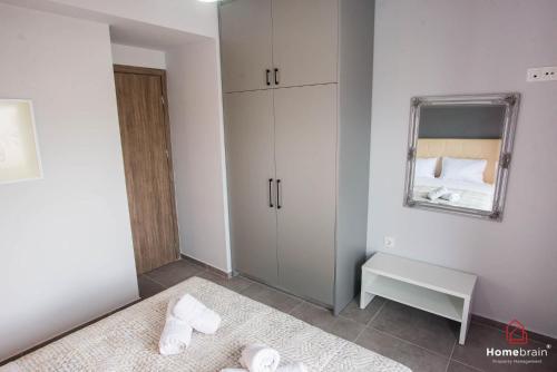 a white room with a bed and a mirror at The Perikleous project by homebrain in Alexandroupoli