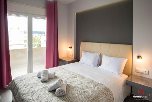 una camera da letto con un grande letto con asciugamani di The Perikleous project by homebrain a Alexandroupoli