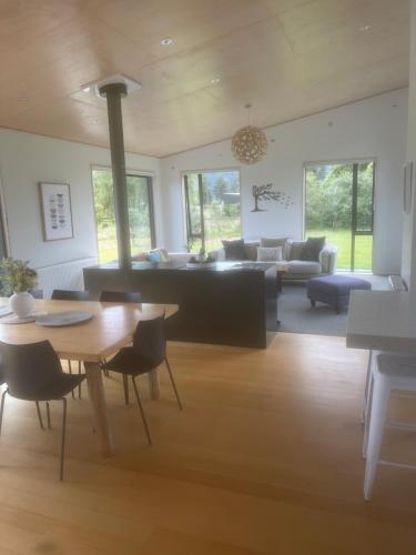 uma sala de estar com uma mesa e um sofá em Mathesons Escape em Fox Glacier