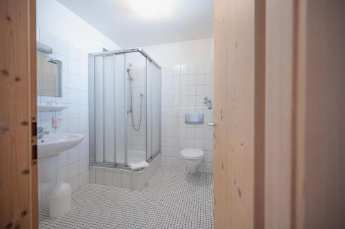 a bathroom with a shower and a toilet and a sink at Gasthof Sondergeld in Hofbieber