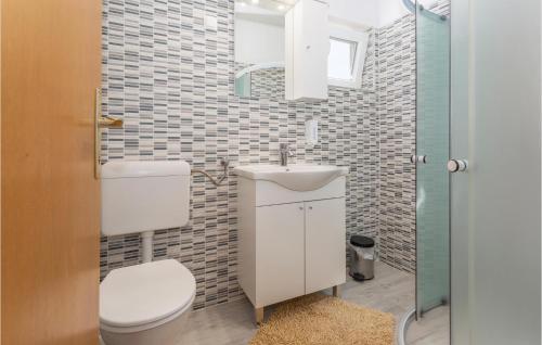 a bathroom with a toilet and a sink and a mirror at Nice Apartment In Stara Baska 1 With Wifi in Stara Baška