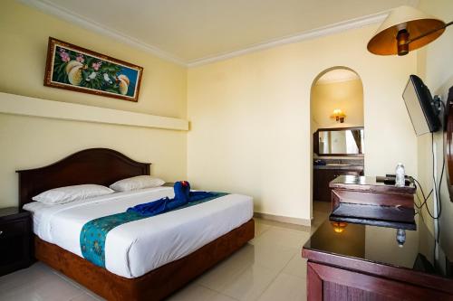 a hotel room with a bed and a piano at Taman Ayu Legian Hotel in Legian