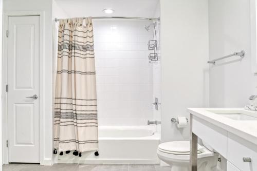 a white bathroom with a shower and a toilet at Cambridge 1BR w Gym WD nr Central Sq BOS-589 in Cambridge
