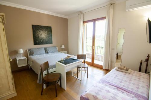 a bedroom with a bed and a desk and a table at B&B Antico Sentiero in Cesena