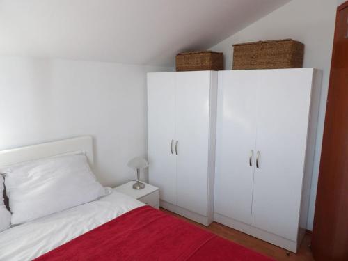 sypialnia z białymi szafkami i łóżkiem z czerwonym kocem w obiekcie Apartment Matea - 20m from the beach w mieście Cesarica