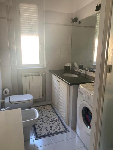 a bathroom with a washing machine and a sink at Appartamento Tevere in Finale Ligure