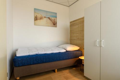 ein Schlafzimmer mit einem Bett und einem Schrank in der Unterkunft Zanddijk 113, Julianadorp aan Zee in Julianadorp