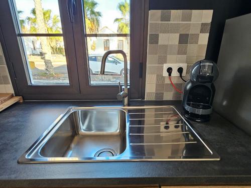 a sink in a kitchen with a window at Casa Azul Montecastillo L7 in Caleta De Fuste