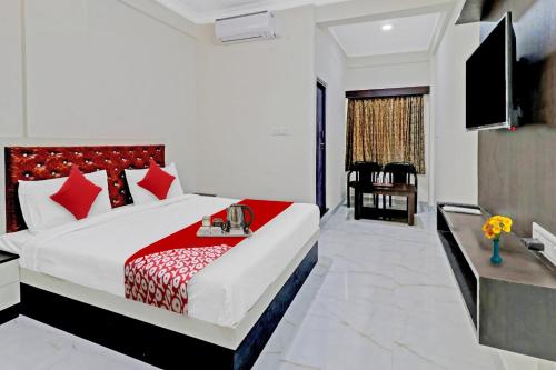 een slaapkamer met een groot bed met rode kussens bij OYO Nra Residency Near Rajarajeshwari Nagar Metro Station in Bangalore