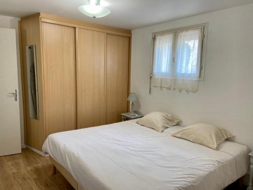 1 dormitorio con 1 cama blanca grande y ventana en Villa Sévigné, en Gréoux-les-Bains