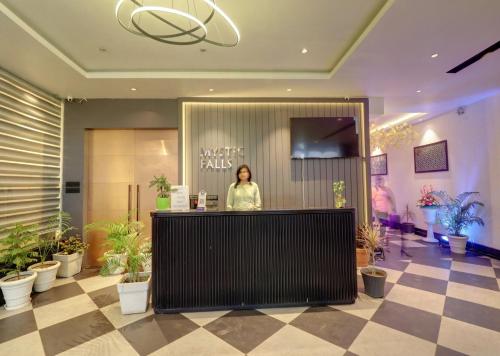 a woman standing at a counter in a lobby at Hotel Mystic Falls in Jaipur
