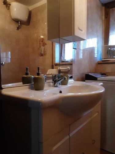 fregadero blanco en una cocina con espejo en La Cascina di Fox en Terni