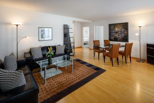 a living room with a couch and a table at Aparthotel Familie Hugenschmidt in Zürich