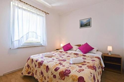 ein Schlafzimmer mit einem großen Bett mit lila Kissen in der Unterkunft Apartment in Porec with balcony, WiFi 819-8 in Poreč