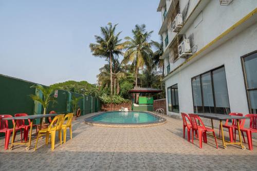 a patio with colorful chairs and a swimming pool at CBC Residency, Karjat in Karjat