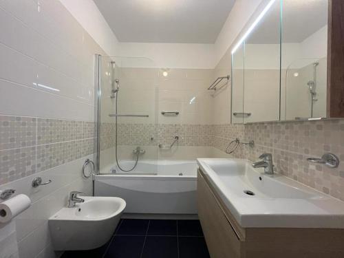a bathroom with a tub and a sink and a tub and a bath tub at 5 Rent Lugano Center in Lugano