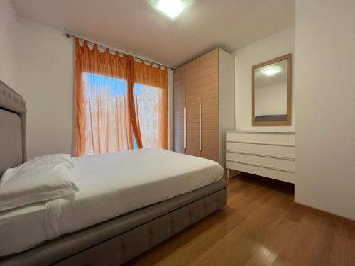 a bedroom with a bed and a dresser and a window at 5 Rent Lugano Center in Lugano