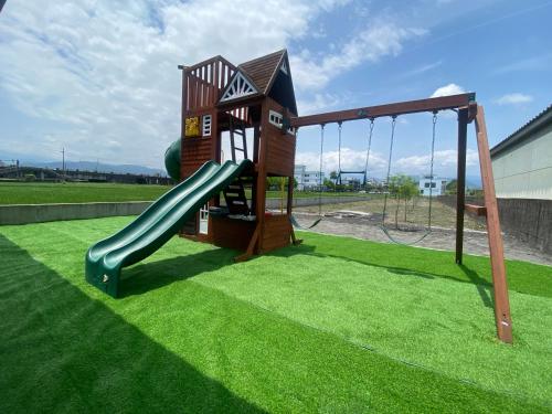 a playground with a slide on the grass at 慕研安農民宿 包棟 KTV 游泳池 羅東運動公園 22p in Yilan City