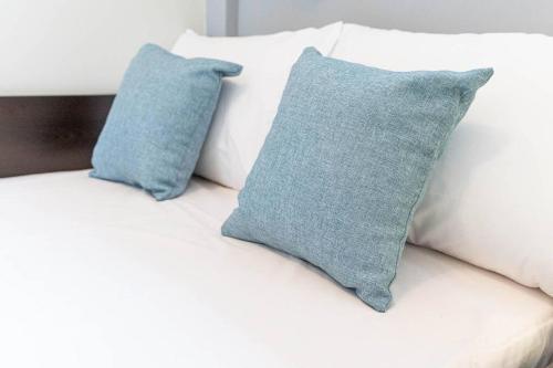 dos almohadas azules sentadas encima de un sofá blanco en Αrgis Home en Preveza
