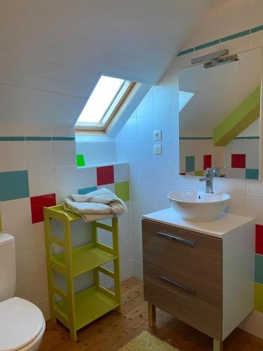 La salle de bains est pourvue d'un lavabo, de toilettes et d'une lucarne. dans l'établissement Les gites du buisson, à Fréhel