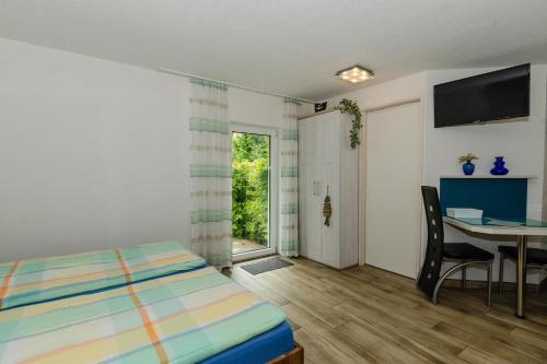 a bedroom with a bed and a table and a window at Appartement-fuer-2-Personen-in-Schaprode-auf-Ruegen-Zi7 in Schaprode
