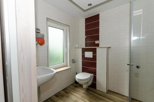 a bathroom with a toilet and a sink at Appartement-fuer-2-Personen-in-Schaprode-auf-Ruegen-Zi7 in Schaprode