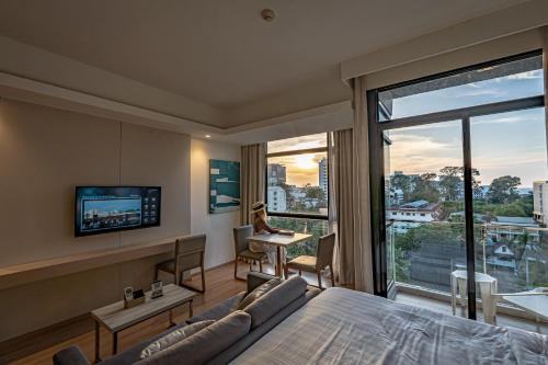 a bedroom with a bed and a television and a desk at Arden Hotel and Residence by At Mind in Pattaya Central