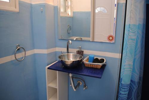a small bathroom with a sink and a mirror at Karmik Concept Apartments in Afantou