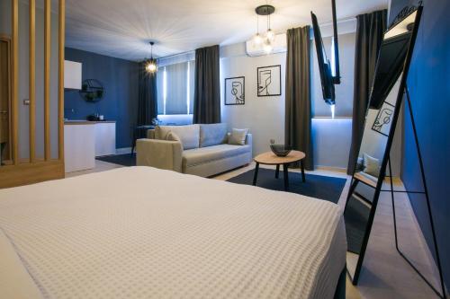 a bedroom with a bed and a living room with a couch at marizas luxury suites #2 in Thessaloniki