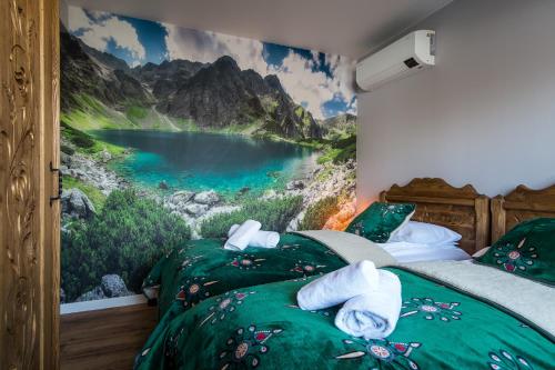 a bedroom with two beds with a painting of a lake at Apartament Luna Góralka in Zakopane