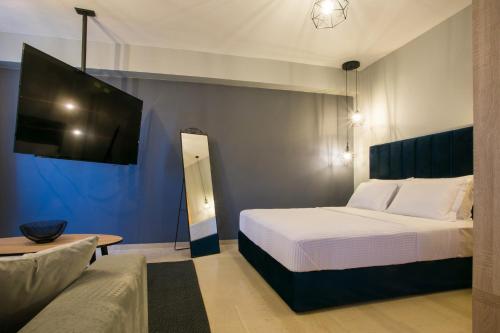 a bedroom with a bed and a flat screen tv at marizas luxury suites #2 in Thessaloniki