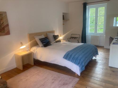 um quarto com uma cama grande e uma janela em Chambres d hôtes du Moulin à papier em Saint-Brieuc
