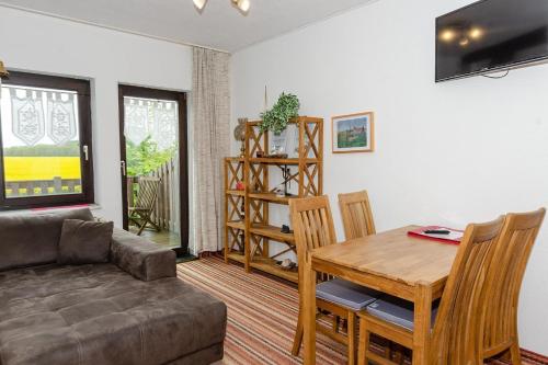 a living room with a couch and a table and chairs at 3-R-Ferienwohnung-fuer-4-Personen-in-Schaprode-auf-Ruegen-Zi3 in Schaprode