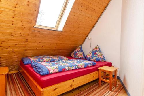 a bed in a wooden room with a window at 3-R-Ferienwohnung-fuer-4-Personen-in-Schaprode-auf-Ruegen-Zi3 in Schaprode