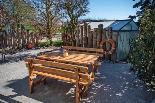a wooden bench sitting next to a wooden fence at 3-R-Ferienwohnung-fuer-4-Personen-in-Schaprode-auf-Ruegen-Zi3 in Schaprode